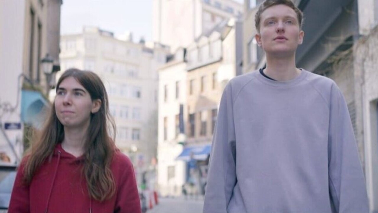 Gruaja në Kutinë: Një Grua e Martuar që Vëzhgohet backdrop